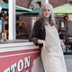 Carol wears an apron and leans on a cotton candy cart in a scene from The Walking Dead.
